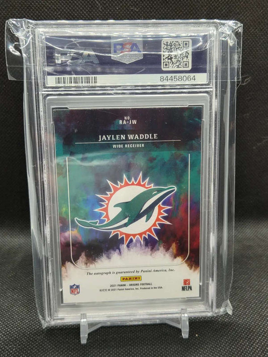Back of 2021 Panini Origins Jaylen Waddle Rookie Autograph Purple parallel showing card number RA-JW and the Panini autograph guarantee, in the PSA holder