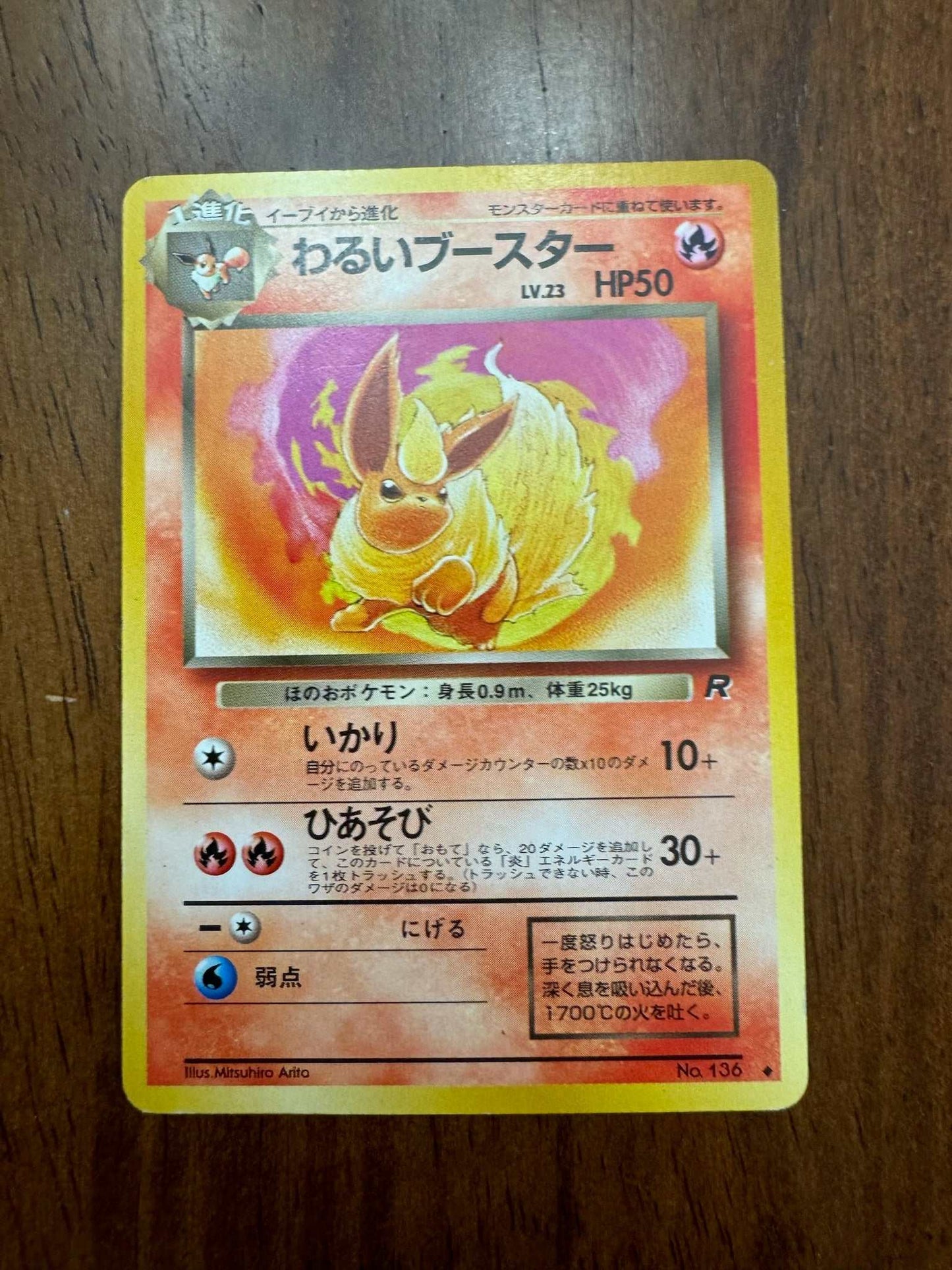 Japanese Dark Flareon Pokemon card Uncommon No. 136 on wooden surface.