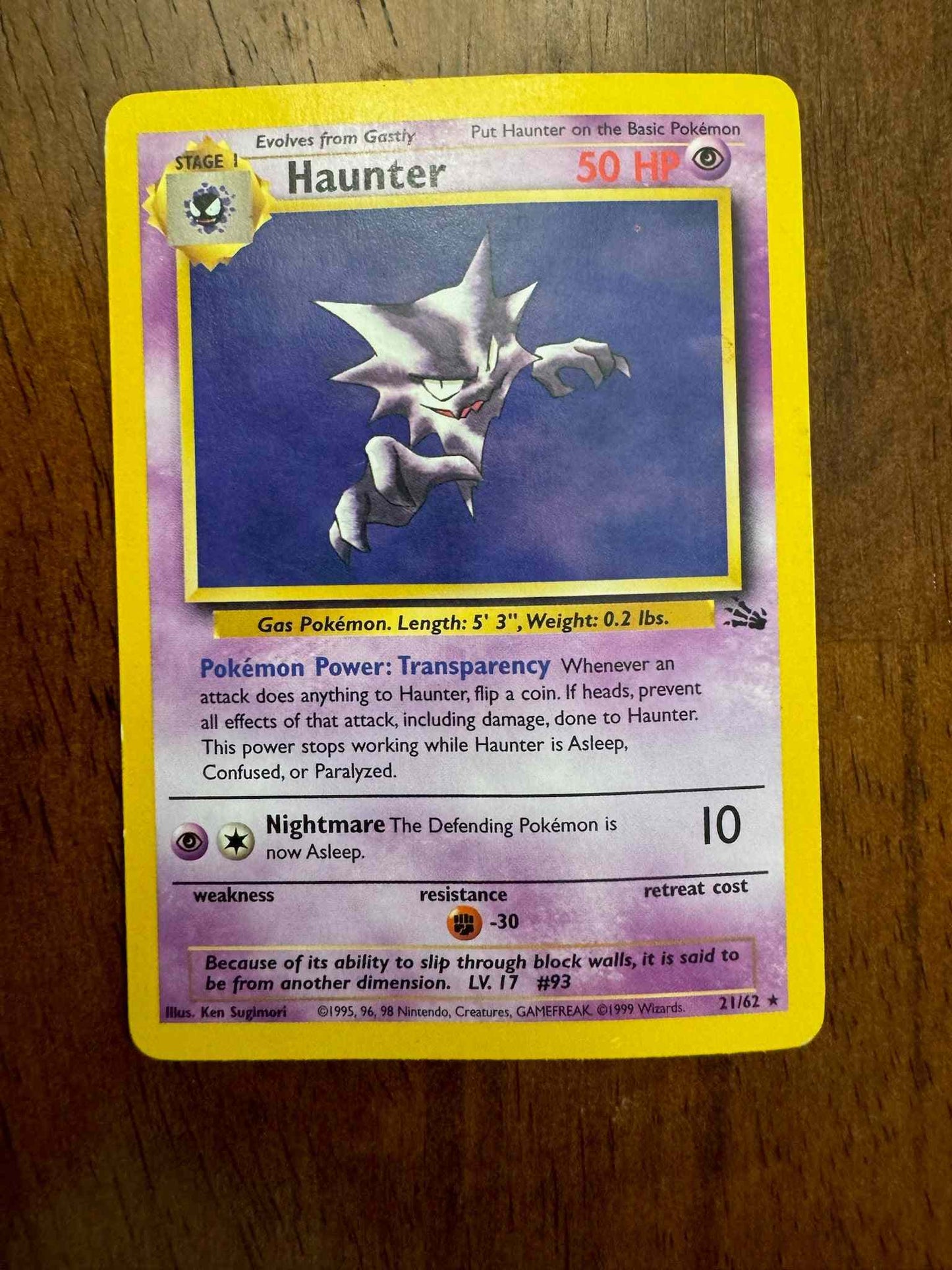 Fossil #21/62 Haunter (21) collectible Pokémon card on wooden surface.