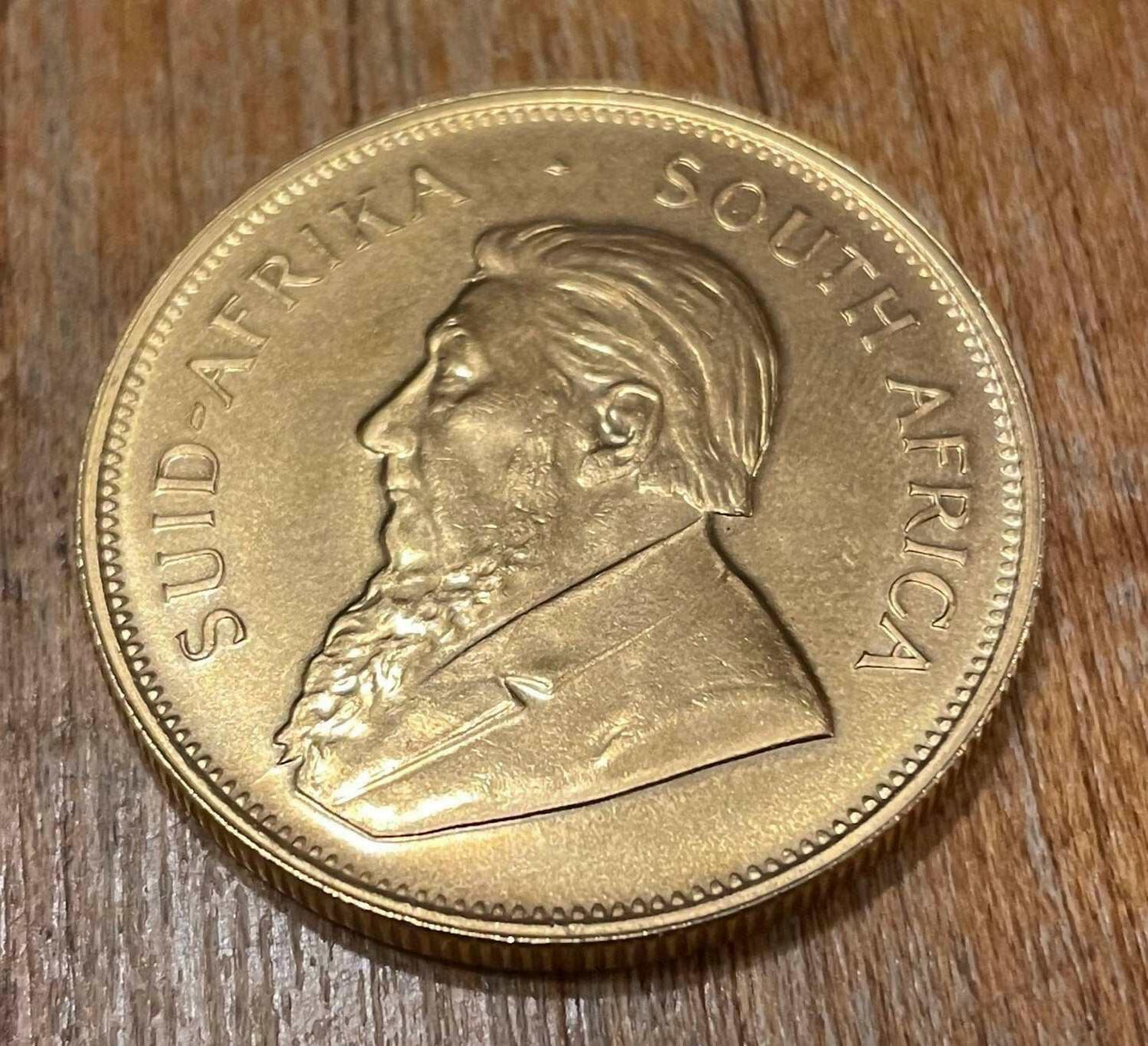 1979 Vintage South African 1 Oz Gold Krugerrand Collectible Bullion Coin on wooden surface.