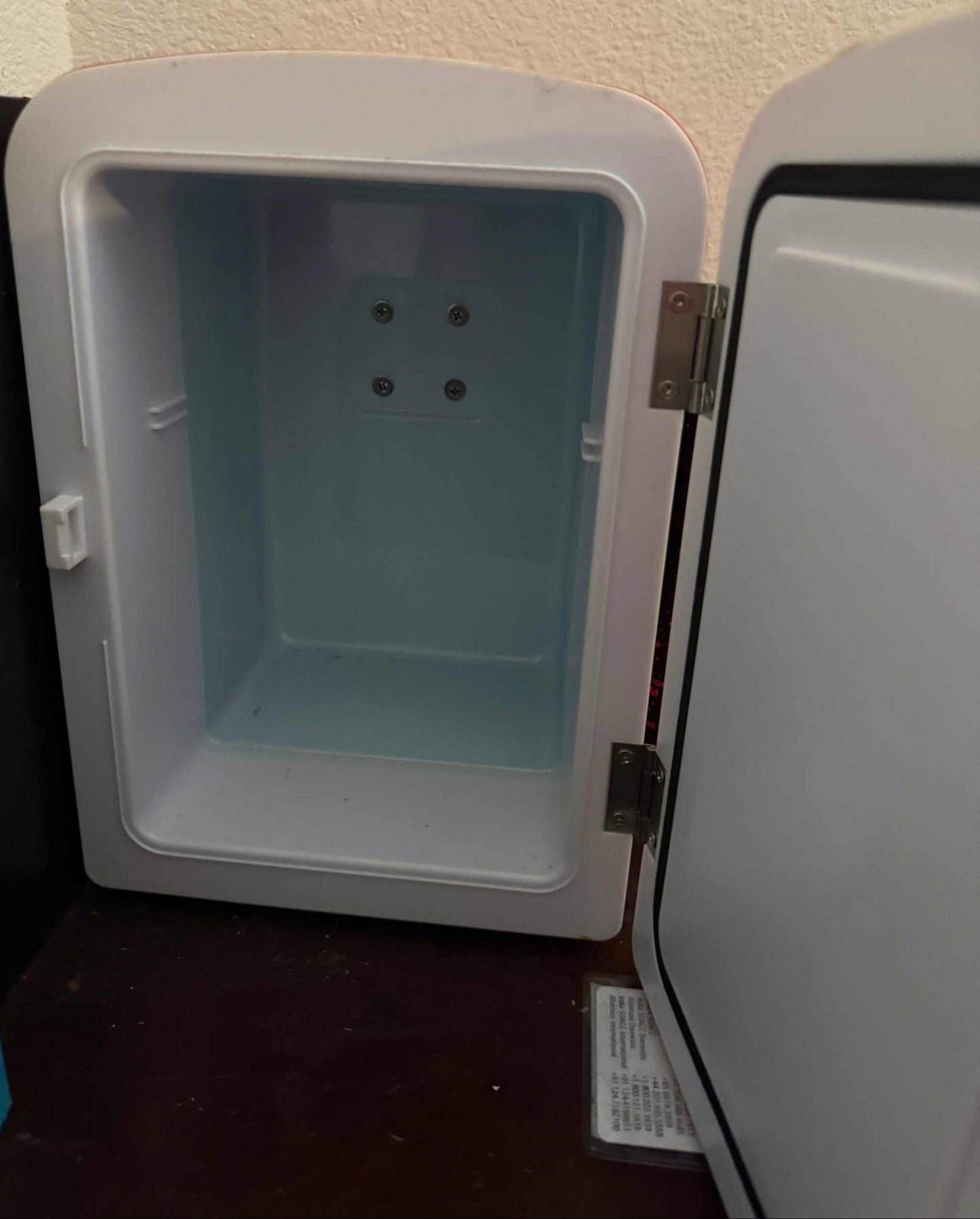 Inside view of empty Coca-Cola Polar Bear mini fridge thermoelectric cooler with open door