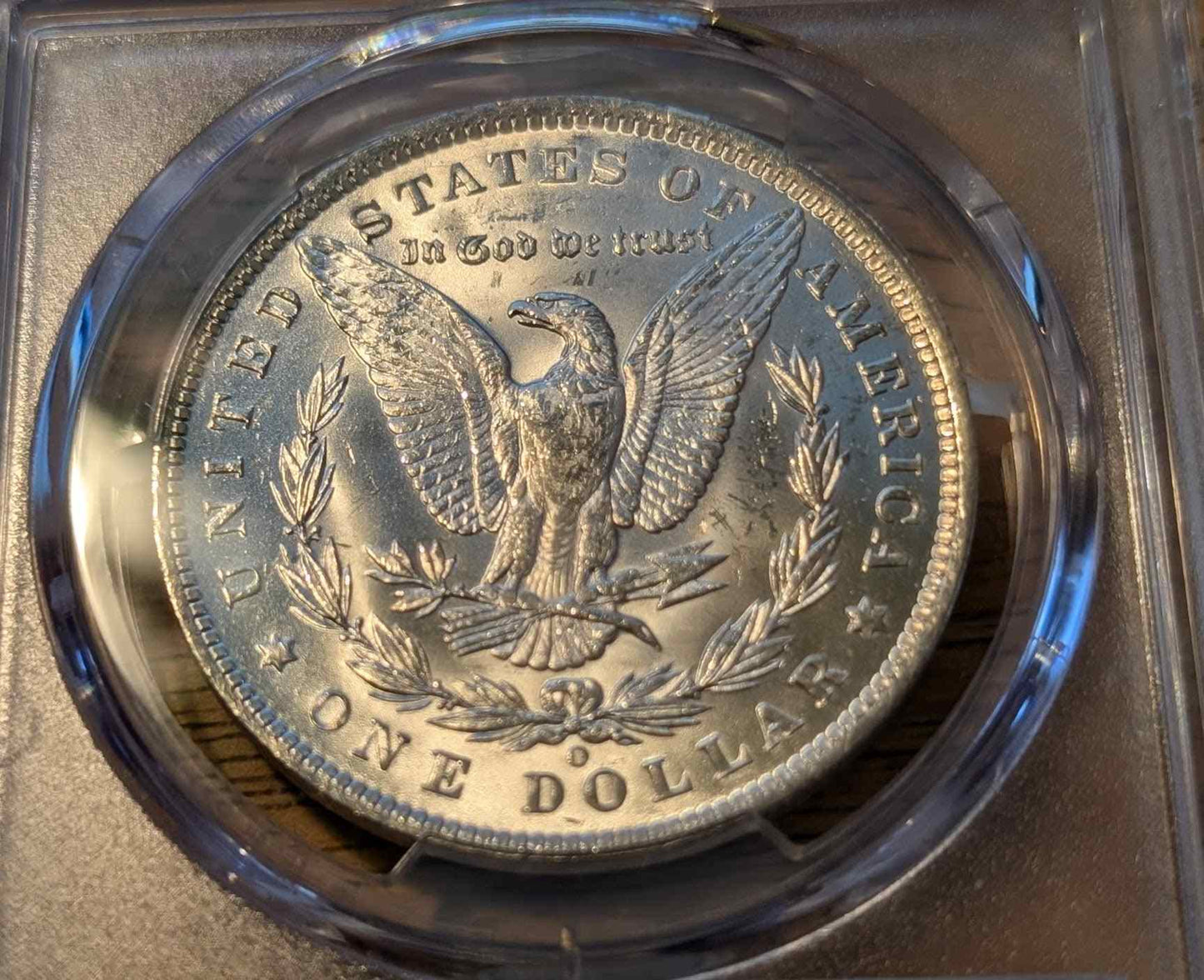 1885 O Morgan Silver Dollar, graded MS63, in a protective case.