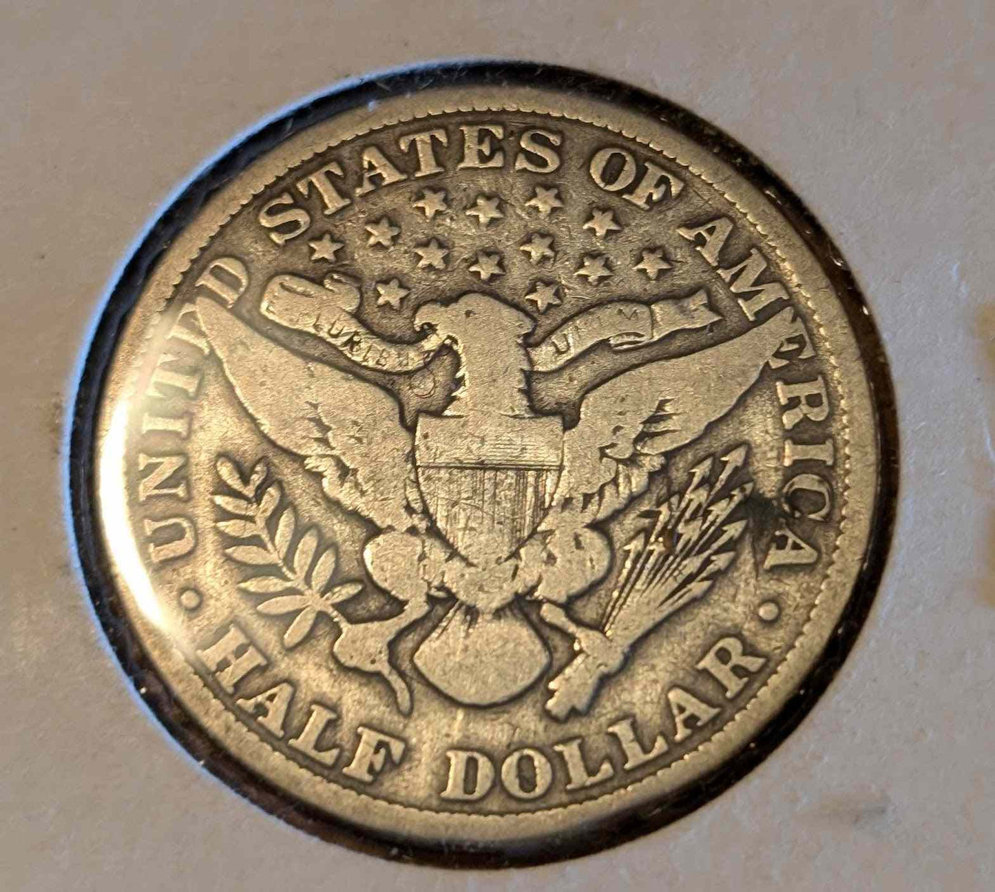 1899 Barber Half Dollar coin with intricate eagle design, 90% silver and 10% copper, valuable for numismatists.