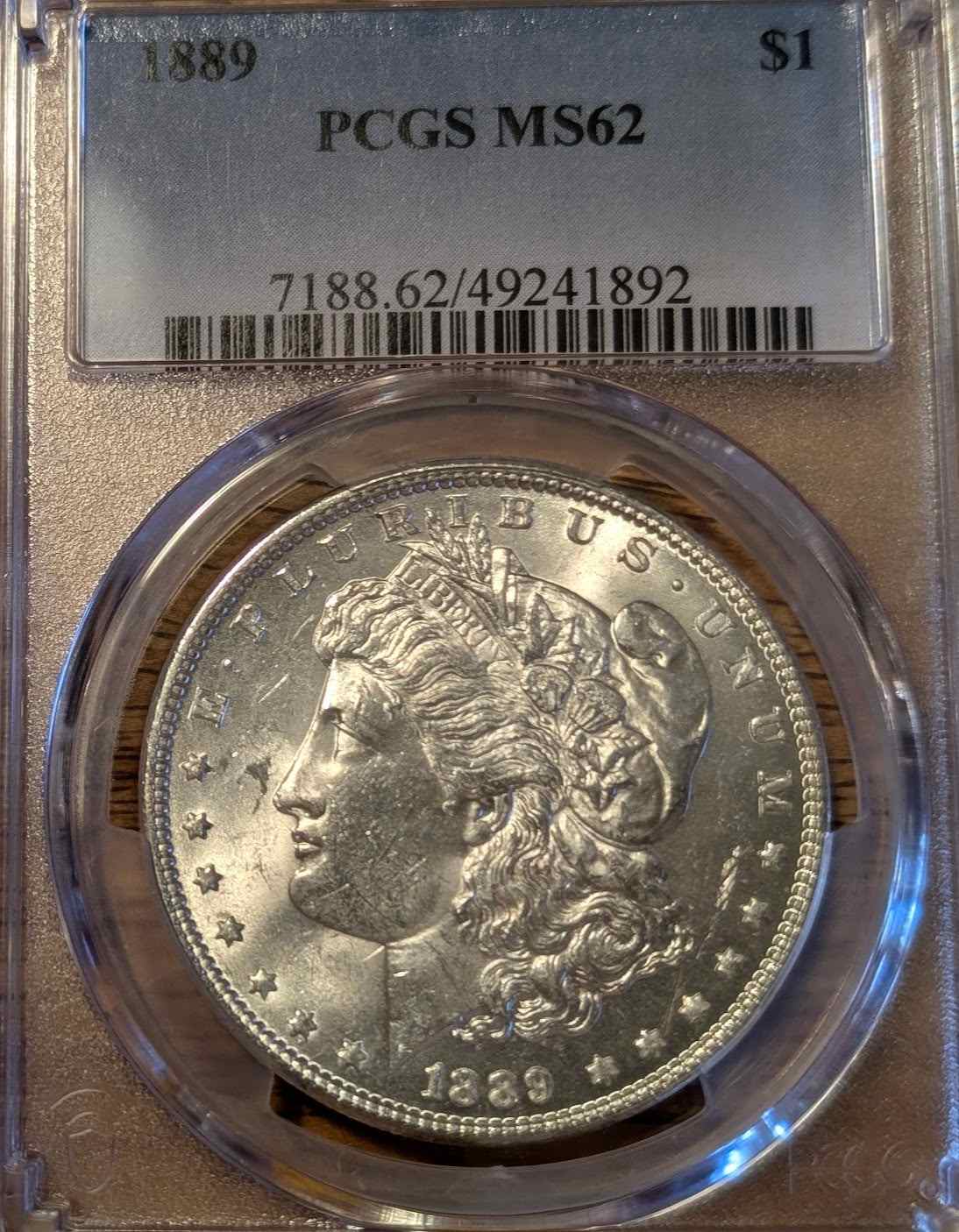 1889 Morgan Silver Dollar MS62 graded coin in protective case.