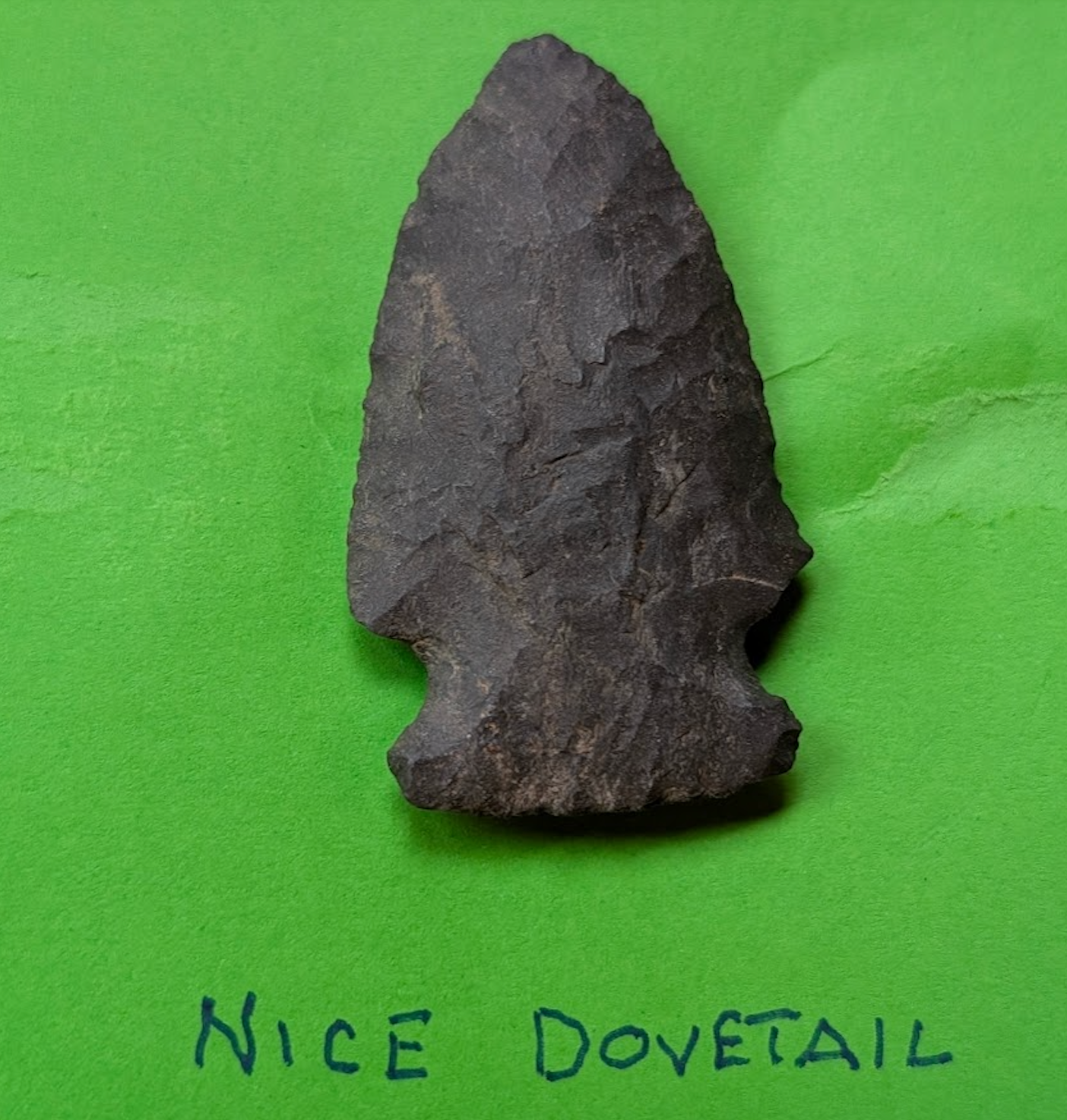 Large dark patina dovetail arrowhead made of chert with deep corner notches and intact tip, Native American artifact display specimen