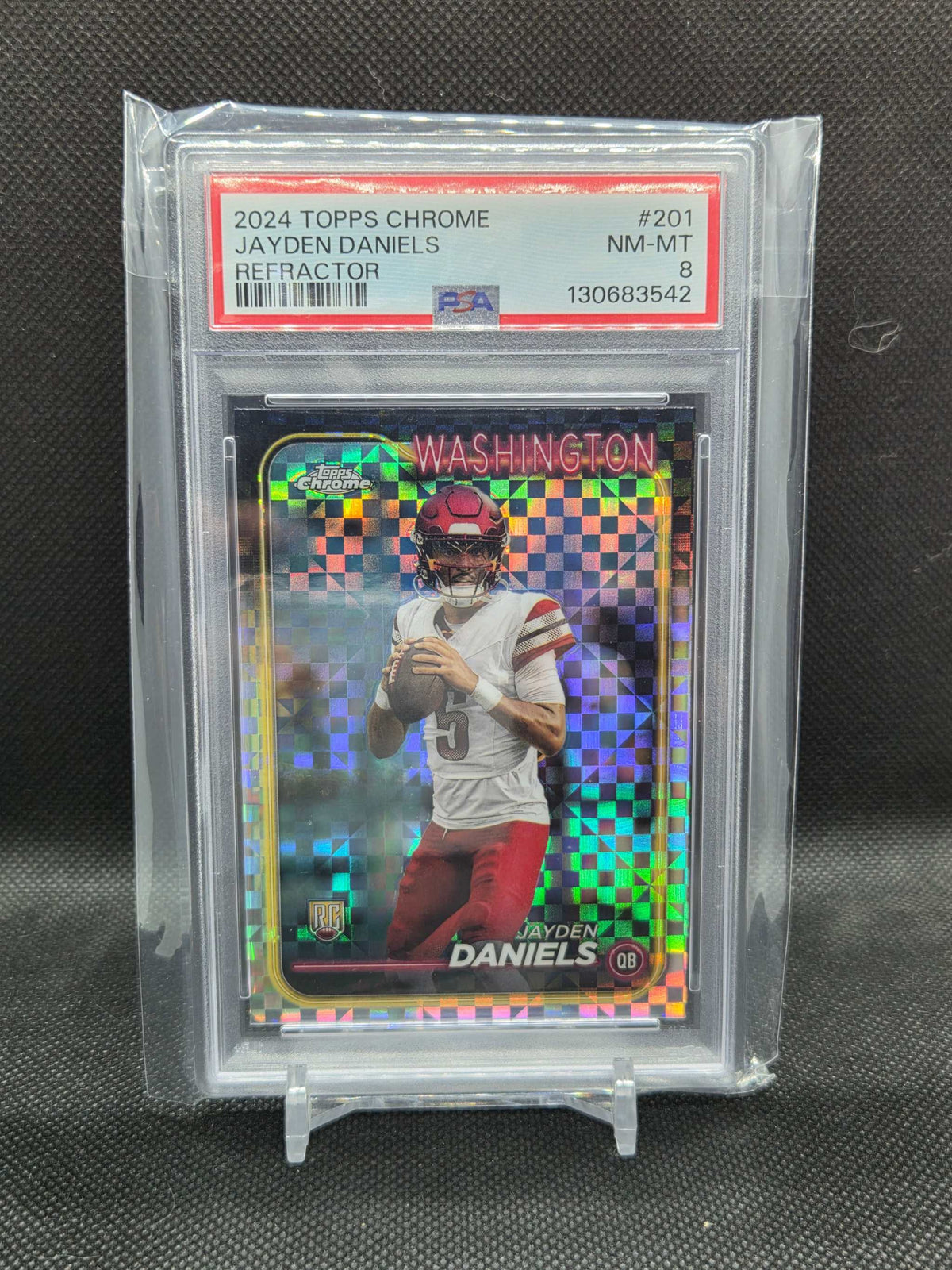2024 Topps Chrome football rookie card featuring Jayden Daniels in Washington uniform with colorful refractor checkerboard pattern and PSA 8 grading.