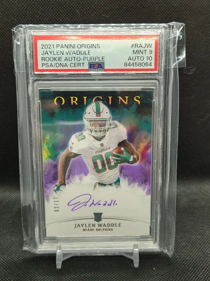 2021 Panini Origins rookie autograph football card, featuring Jaylen Waddle in a white Dolphins uniform, purple watercolor design and signature.