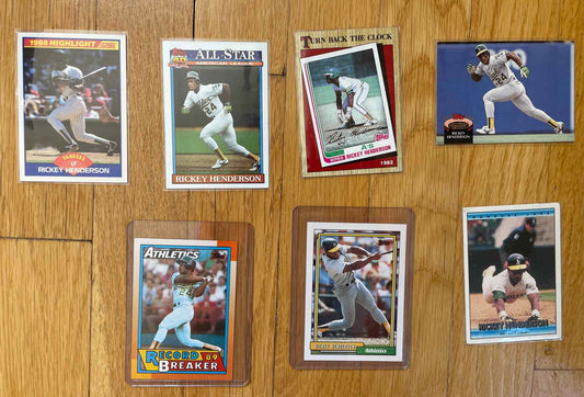 Ricky Henderson sports card bundle with seven collectible cards on wooden surface.