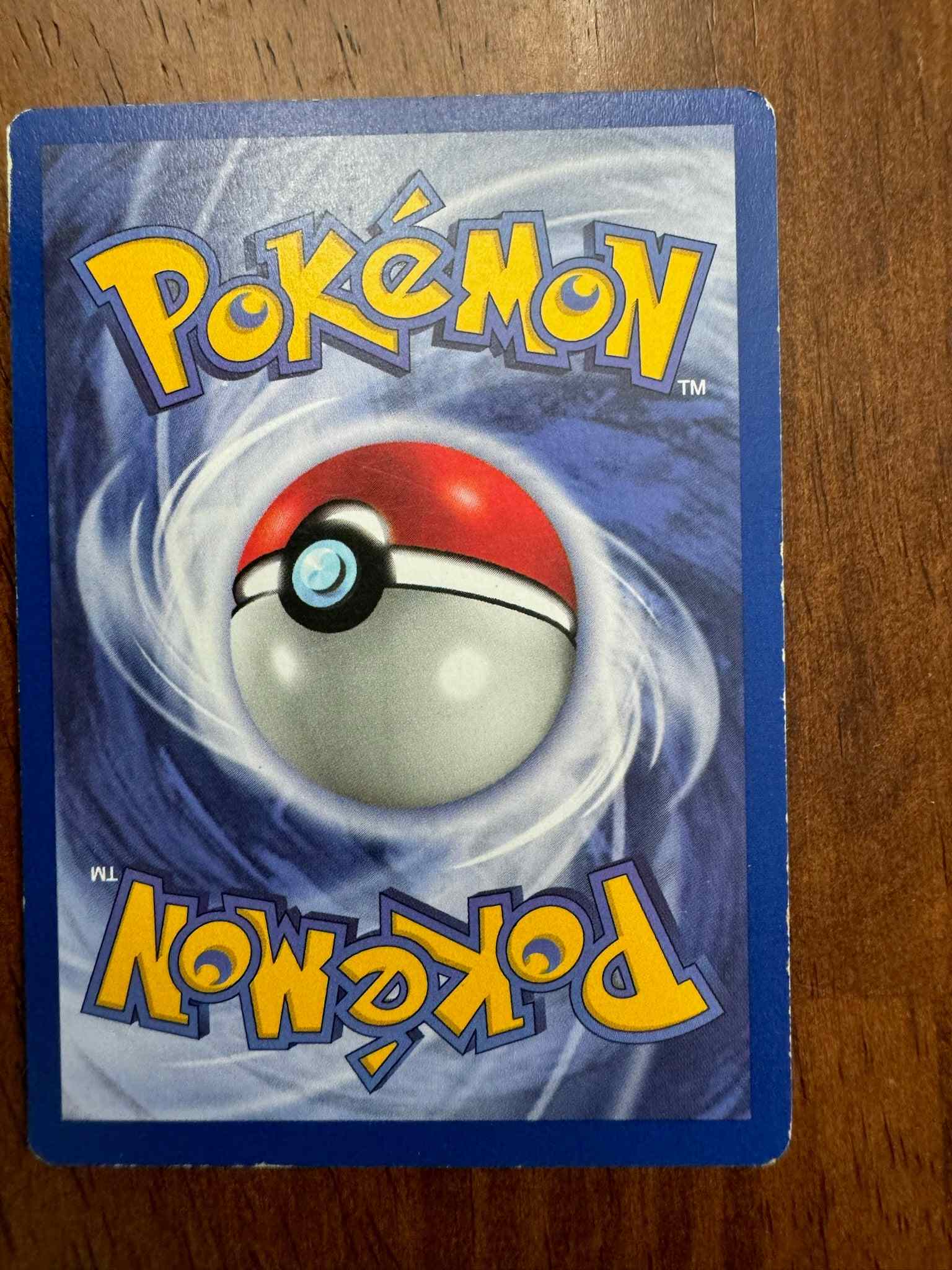 Base Set 2 023130 Dugtrio Pokémon cardback on wooden surface.