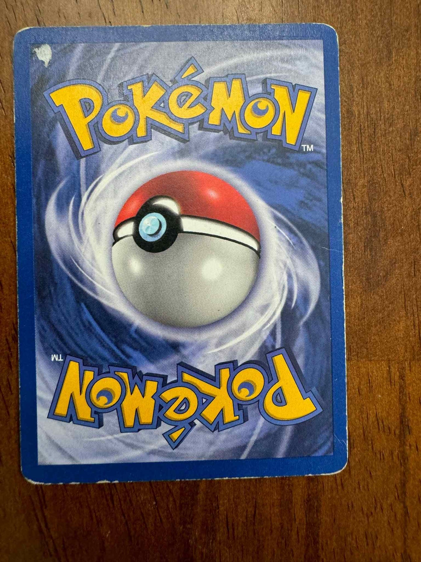 Jungle #27/64 Snorlax Pokémon card with Pokéball design on wooden surface.