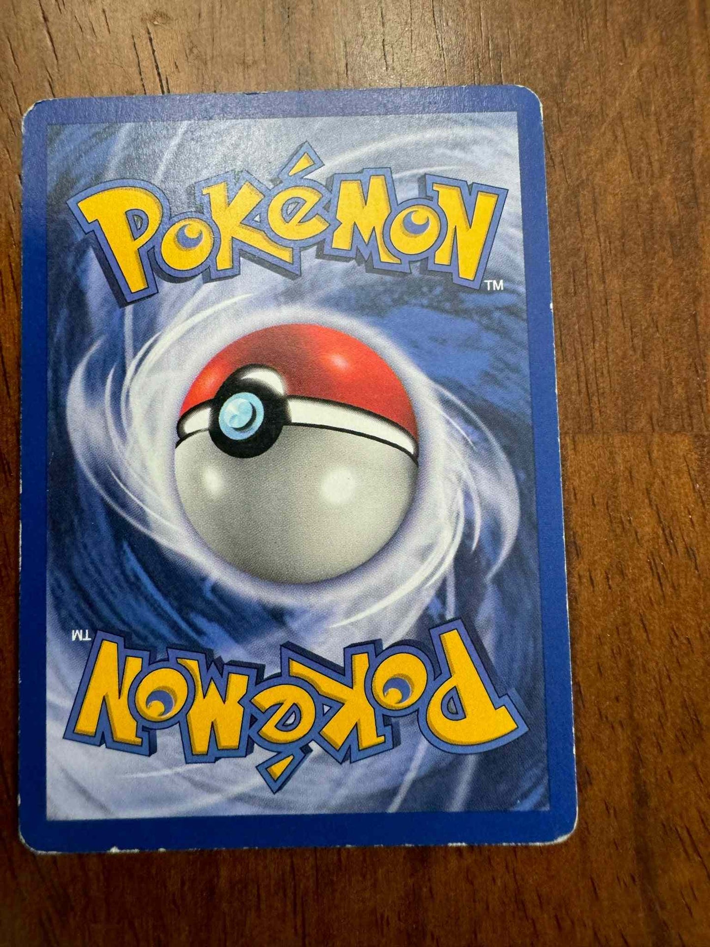 Base Set #022/102 Pidgeotto collectible trading card on a wooden surface.