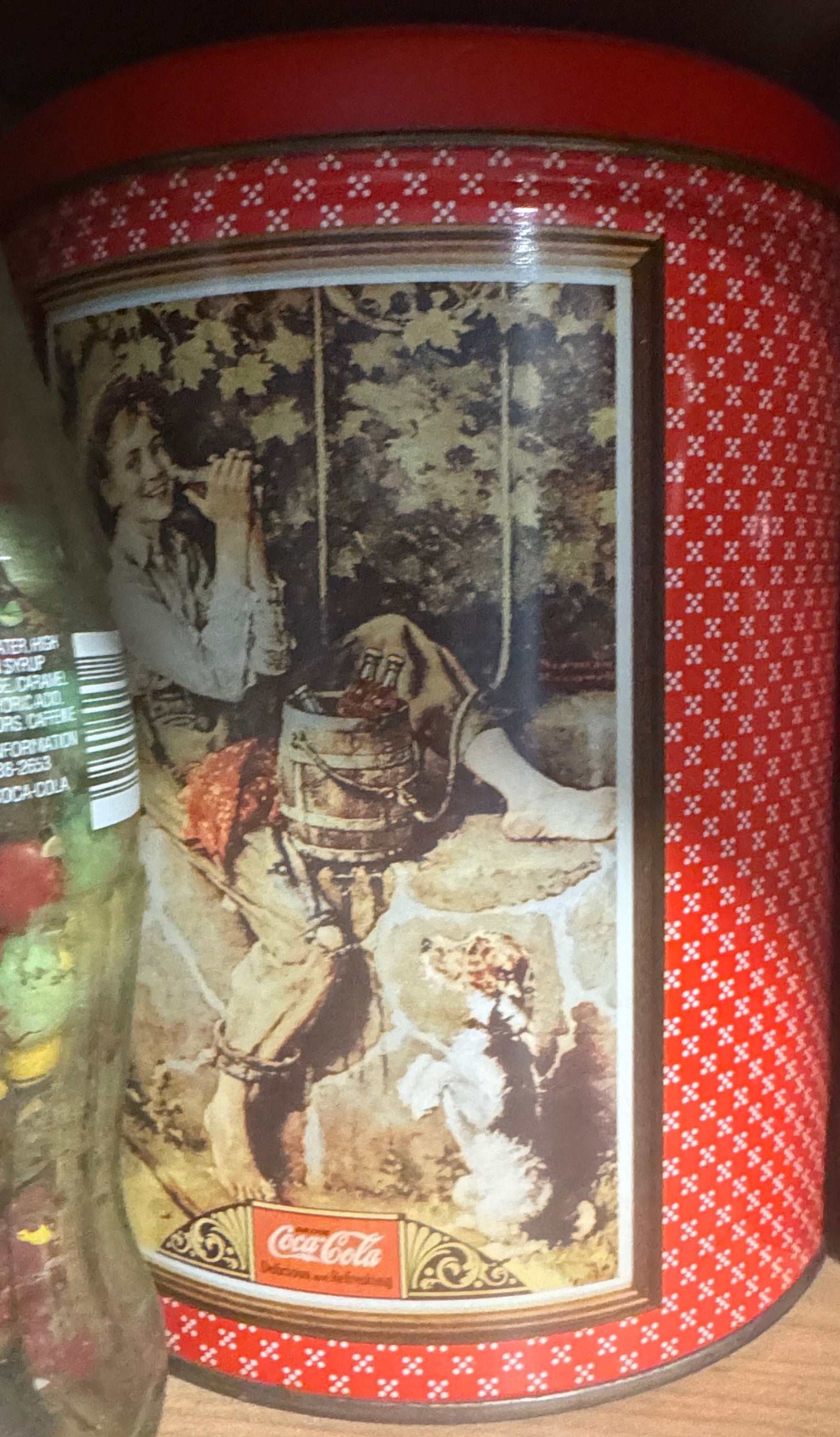 Vintage Coca-Cola holiday tin with Santa winter scene and red patterned background