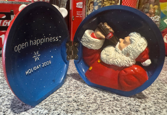 Coca-Cola Open Happiness Holiday 2009 hinged figurine with 3D Santa Claus drinking Coke and "Open Happiness" slogan inside