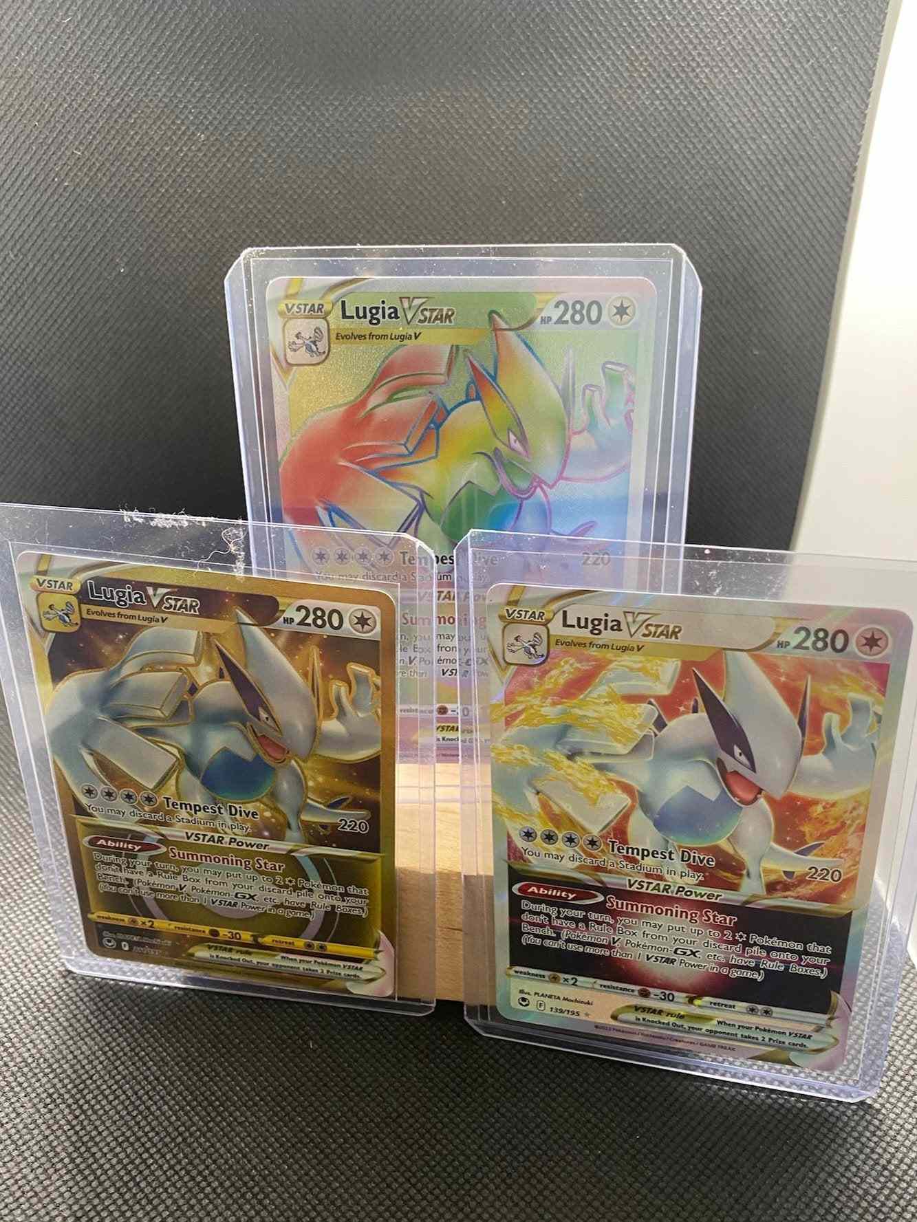 Lugia VSTAR TCG cards lot, featuring rainbow and gold secret rare designs in near mint condition.