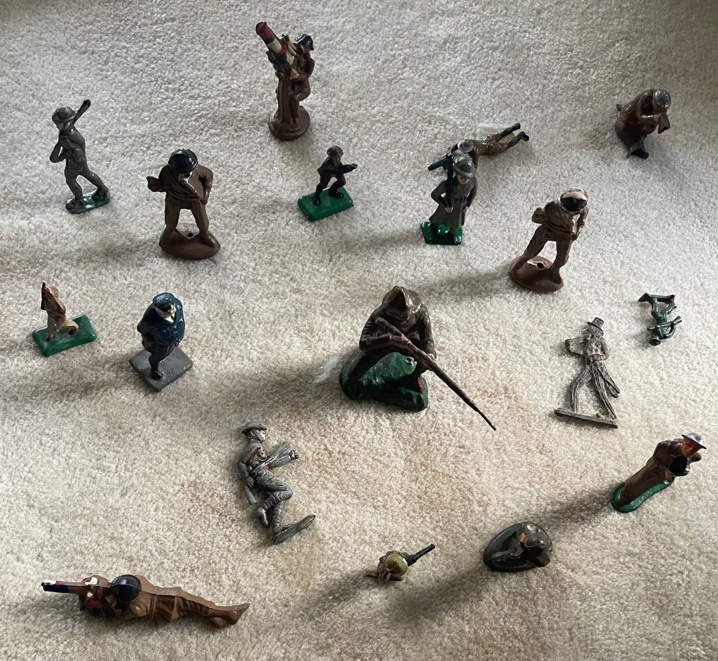 Lot of vintage cast toy combat military soldier figurines on display.