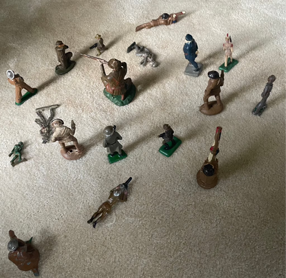 Vintage cast toy combat military soldier figurines on display.