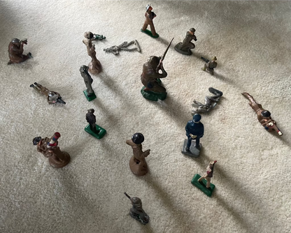 Lot of vintage military soldier figurines on carpet.