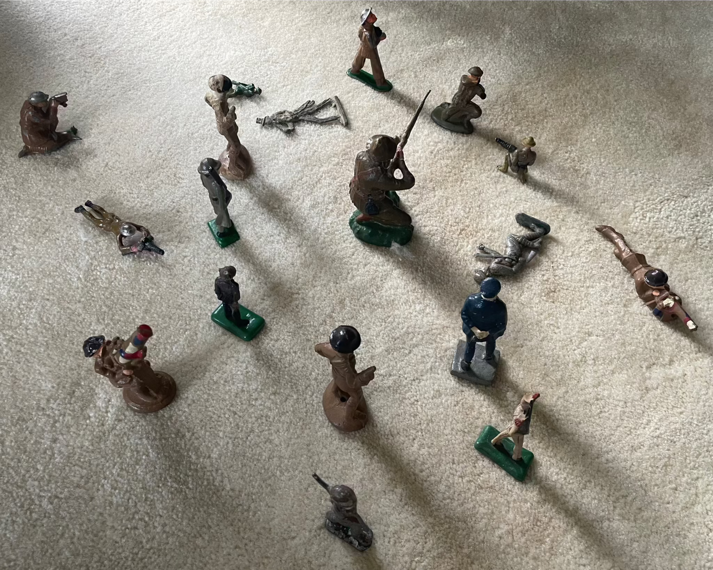 Lot of vintage cast toy combat military soldier figurines on display.