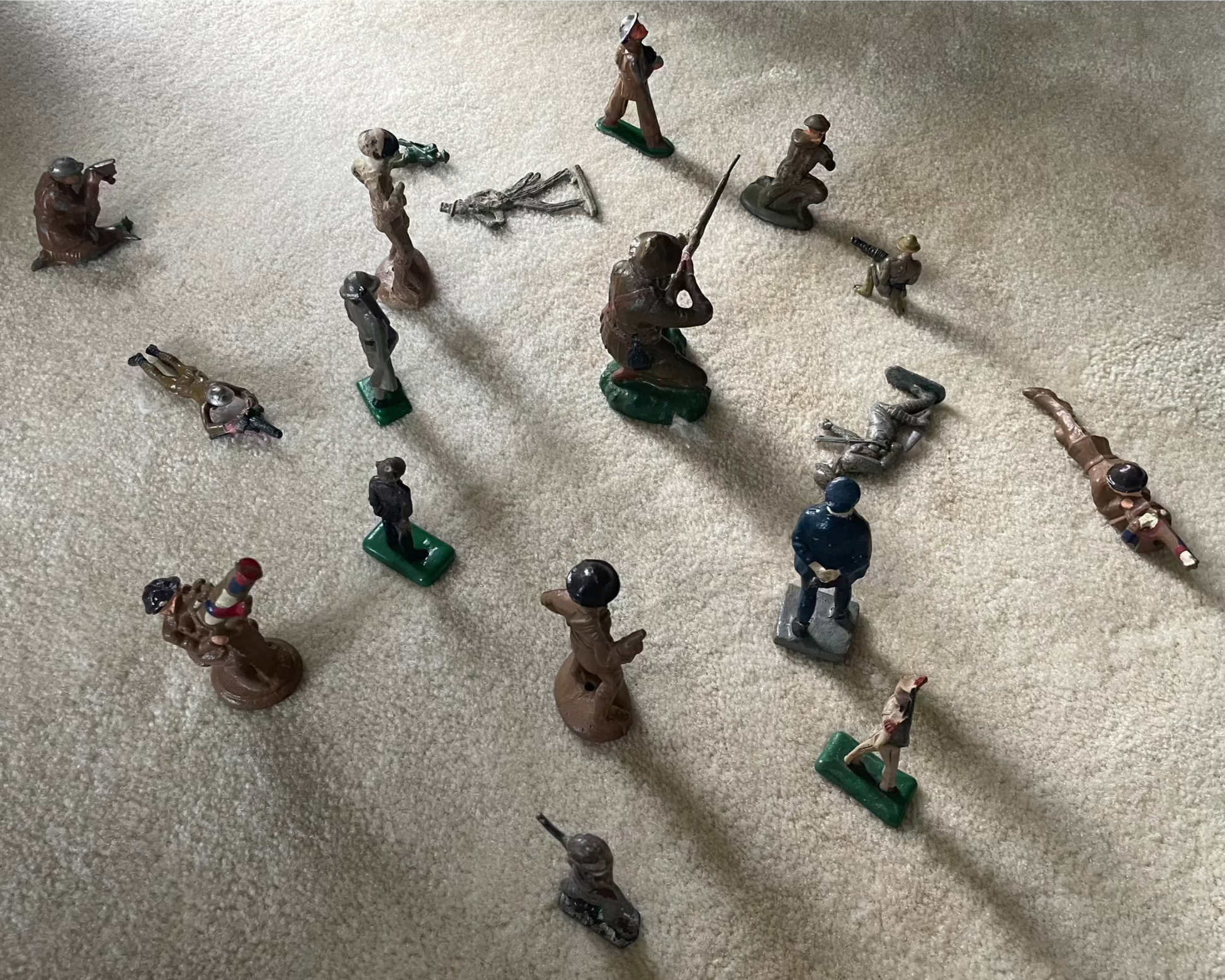 Lot of vintage cast toy combat military soldier figurines on display.