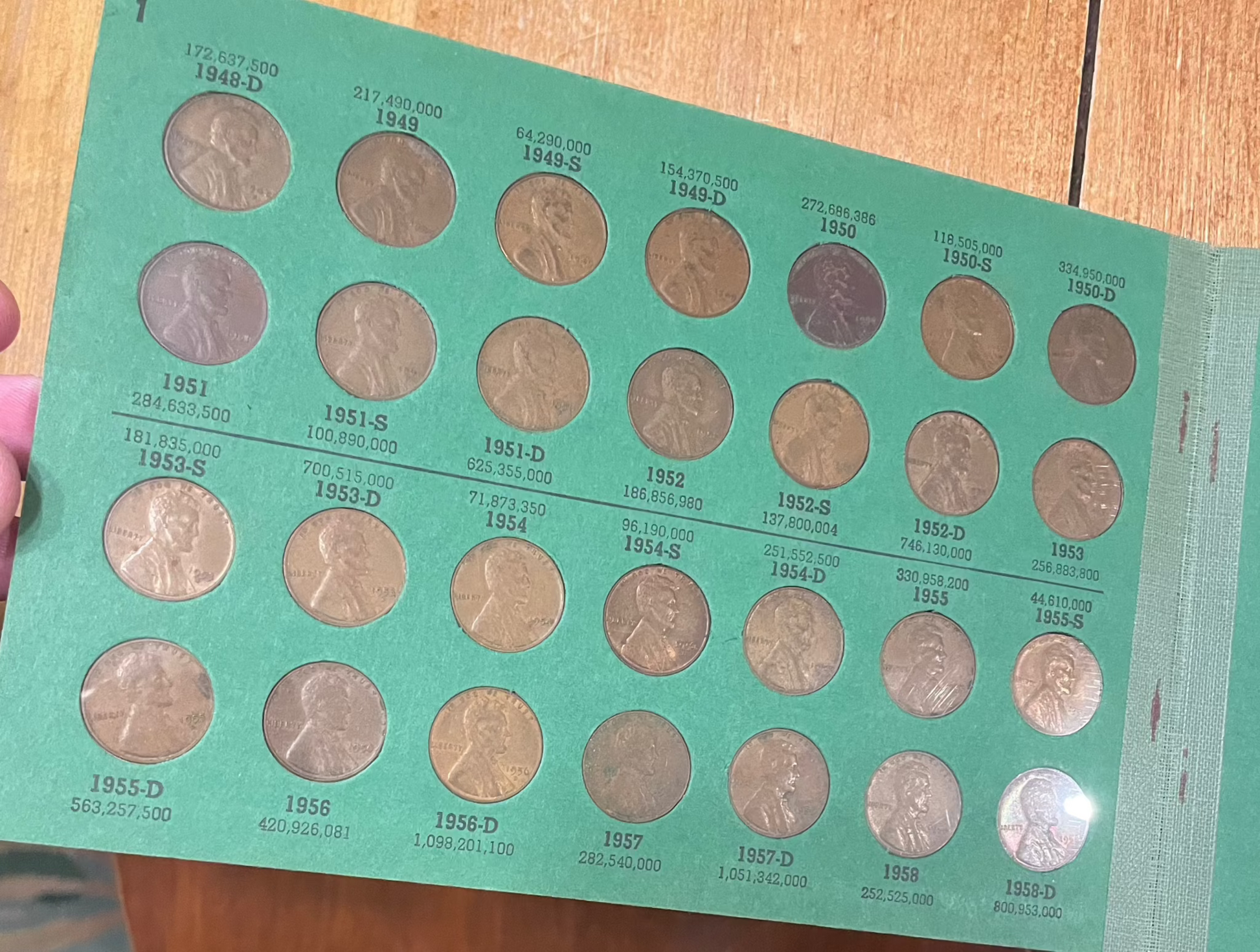 Collector's lot penny book with historical coins, including Indian Head pennies and near-mint 1943 steel cents bonus.
