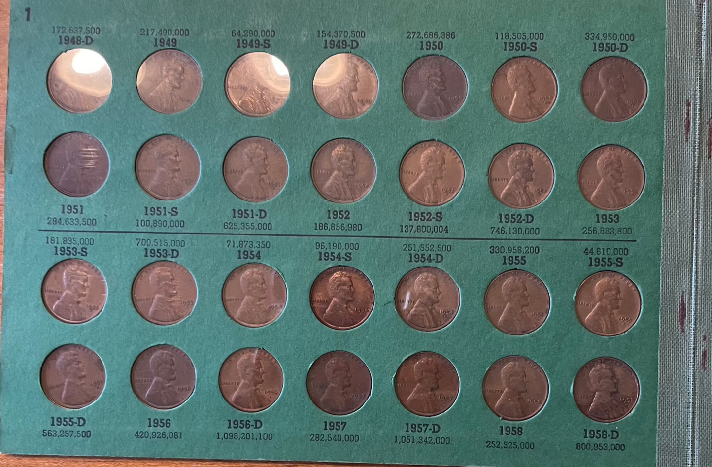 Collector's lot featuring Lincoln penny book with assorted historical coins, including Indian head pennies and near-mint 1943 steel cents.