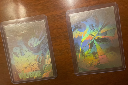 1992 Impel Marvel Universe Series 1 hologram cards featuring Wolverine and Gambit in protective sleeves on a wooden surface.