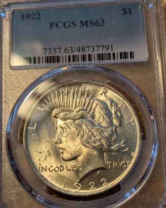 1922 Peace Silver Dollar graded MS63 in protective case.