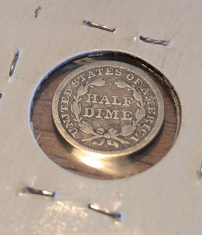 Liberty Seated 1841 silver coin with stars and detailed design.
