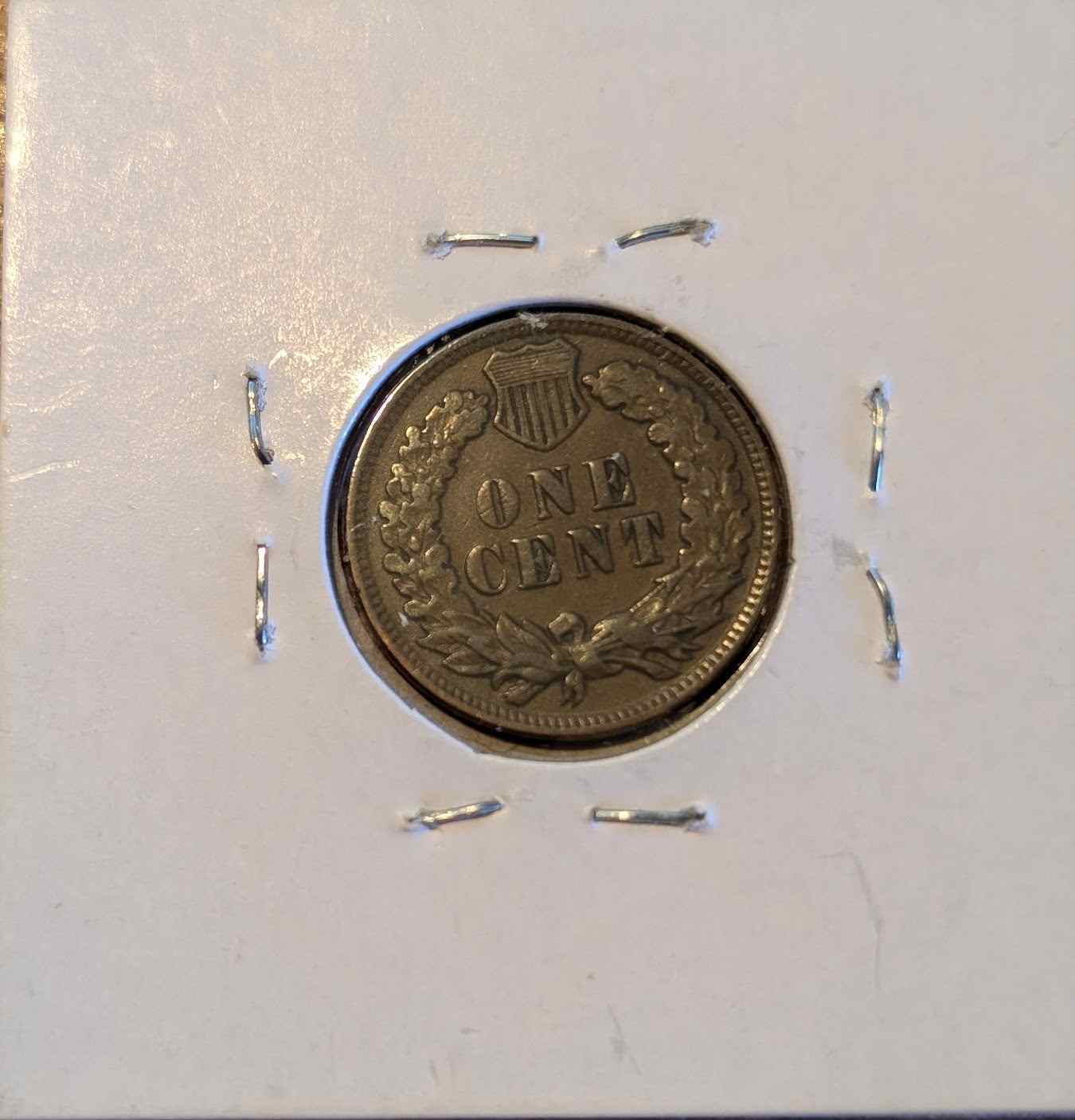 1907 Indian Head Cent in protective holder, showcasing intricate design and detail.