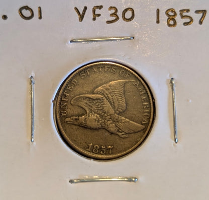 1857 Flying Eagle Cent coin in protective holder, showcasing intricate design.
