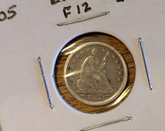 1853 Seated Liberty Half Dime in protective display highlighting arrows detail.