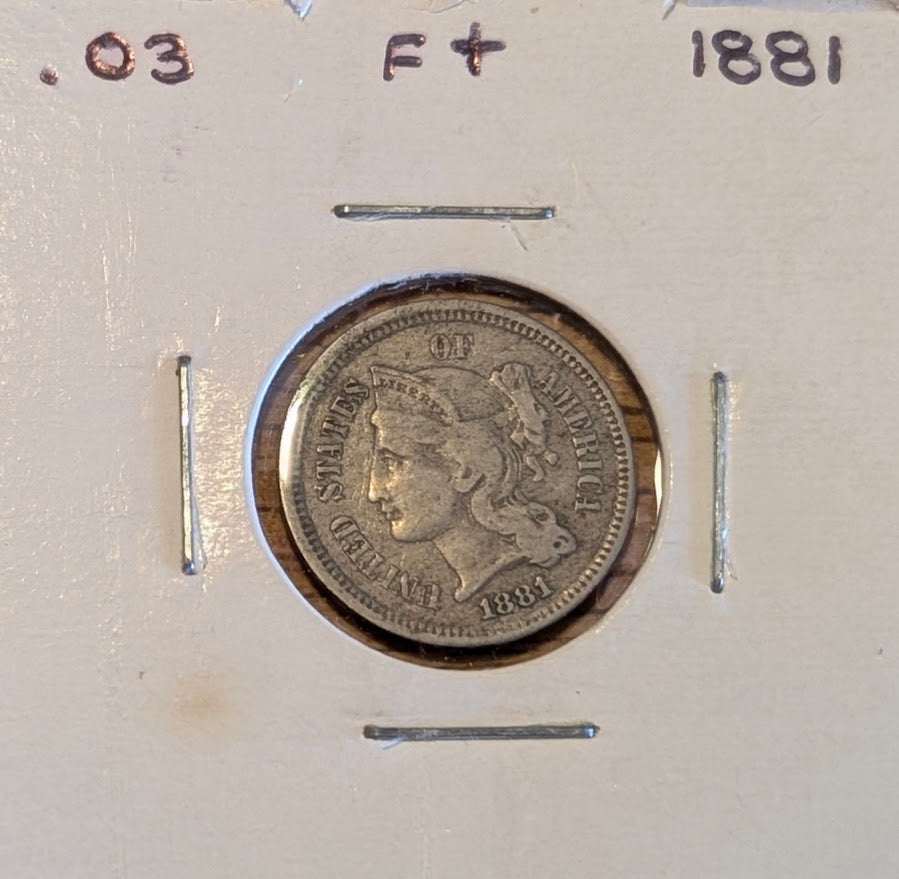 1881 Three-Cent Nickel coin in fine condition showing worn but clear details of the 19th-century US currency piece