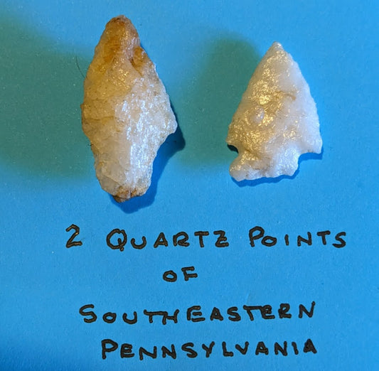Two authentic Native American quartz arrowheads from southeastern Pennsylvania on blue background