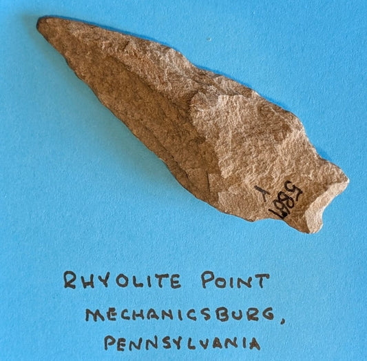 Native American rhyolite projectile point from Mechanicsburg, Pennsylvania on blue background