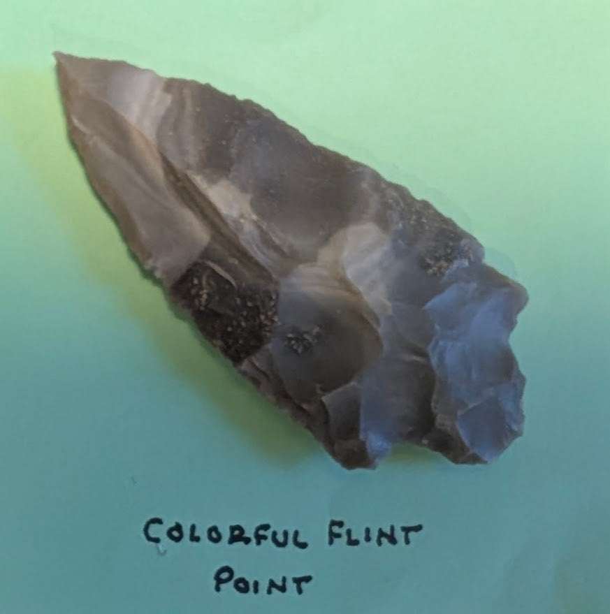 Colorful banded flint Native American arrowhead with multicolored natural banding and triangular bifacial flaked blade