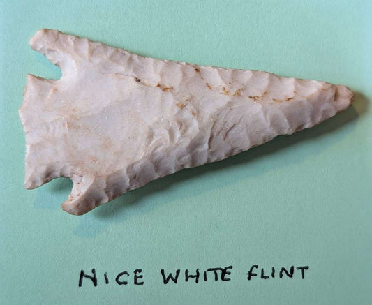 Large white flint Native American notched arrowhead with triangular form and detailed flaking patterns