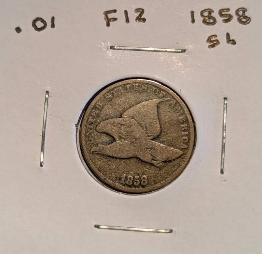 1858 Flying Eagle Cent in worn brown copper-nickel, showing a flying eagle, visible date, and handwritten F12 holder marking.