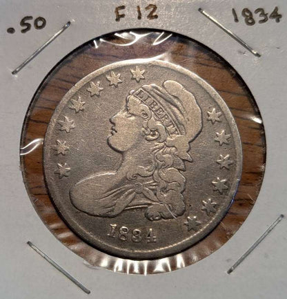 1834 Capped Bust Half Dollar silver coin with a worn, gray-toned surface, Liberty portrait, and surrounding stars in a holder.