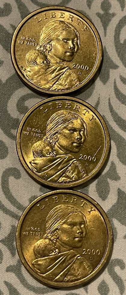 Three circulated 2000 Sacagawea $1 coins showing obverse side with Sacagawea portrait